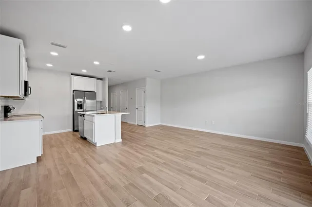 a view of kitchen with granite countertop cabinets and refrigerator