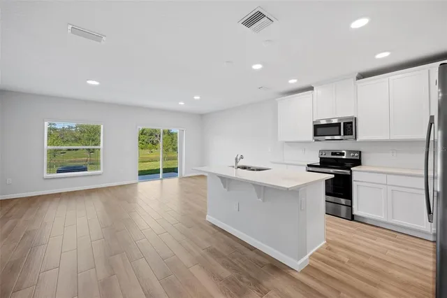 a kitchen with stainless steel appliances granite countertop a stove a sink and a microwave