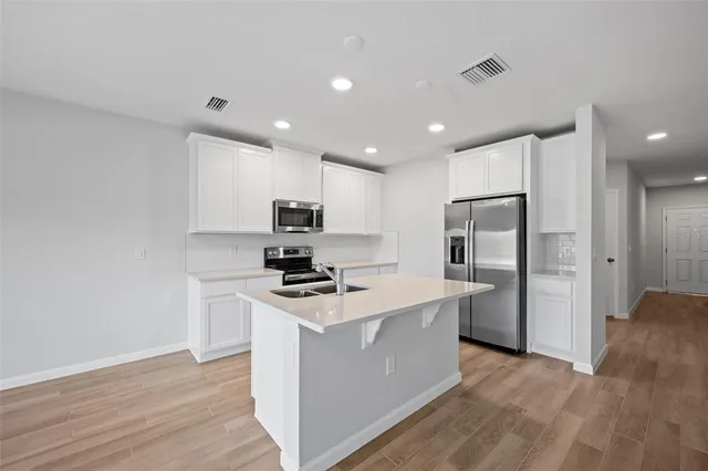 a kitchen with stainless steel appliances a refrigerator stove a sink and a microwave