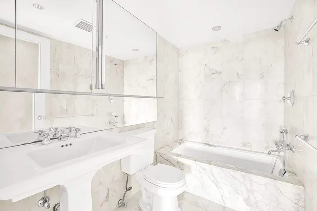 a bathroom with a sink mirror and shower