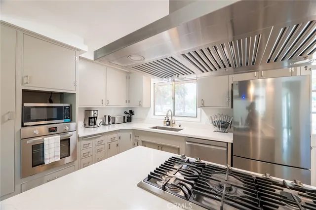 a kitchen with stainless steel appliances a refrigerator sink and microwave