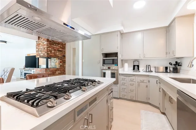 a kitchen with stainless steel appliances granite countertop a stove sink and cabinets