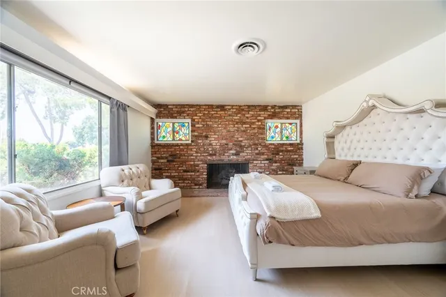 a bedroom with a bed couch and a large window