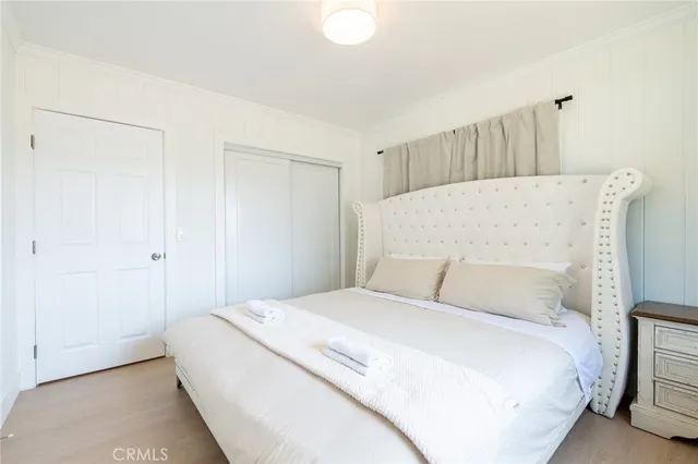 a bedroom with a bed and a white cabinet