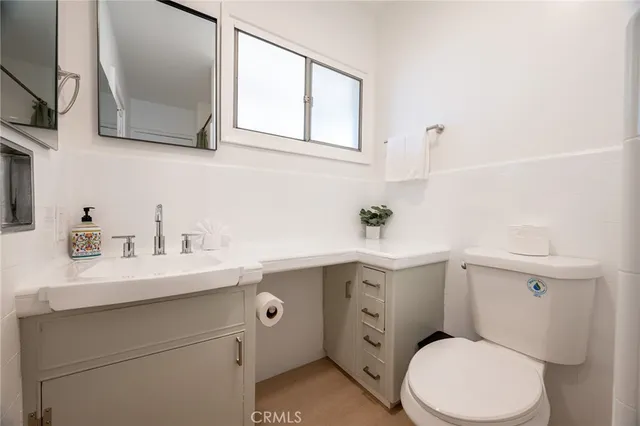a bathroom with a sink a toilet and mirror
