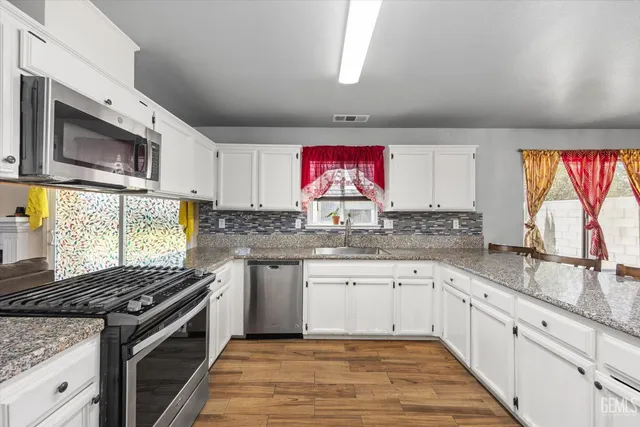 a kitchen with stainless steel appliances granite countertop a stove and a sink