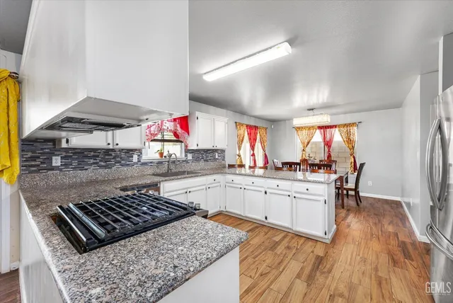 a kitchen with granite countertop a sink stove and cabinets