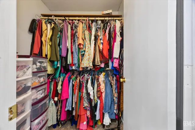 a view of walk in closet with clothes
