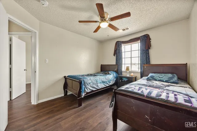 a bedroom with two beds and wooden floor
