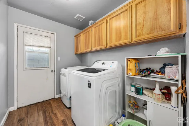 a utility room with fridge dryer and washer