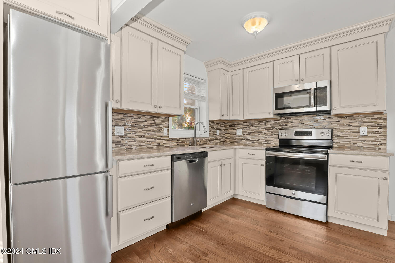 71 Old Field Point Road Greenwich, CT 06830 - Photo 6 of 23 a kitchen with white cabinets stainless steel appliances and a refrigerator