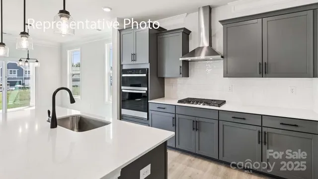 a kitchen with stainless steel appliances a sink a stove and refrigerator