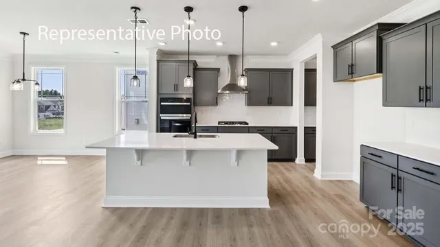 a large kitchen with stainless steel appliances a large center island attached withe living room