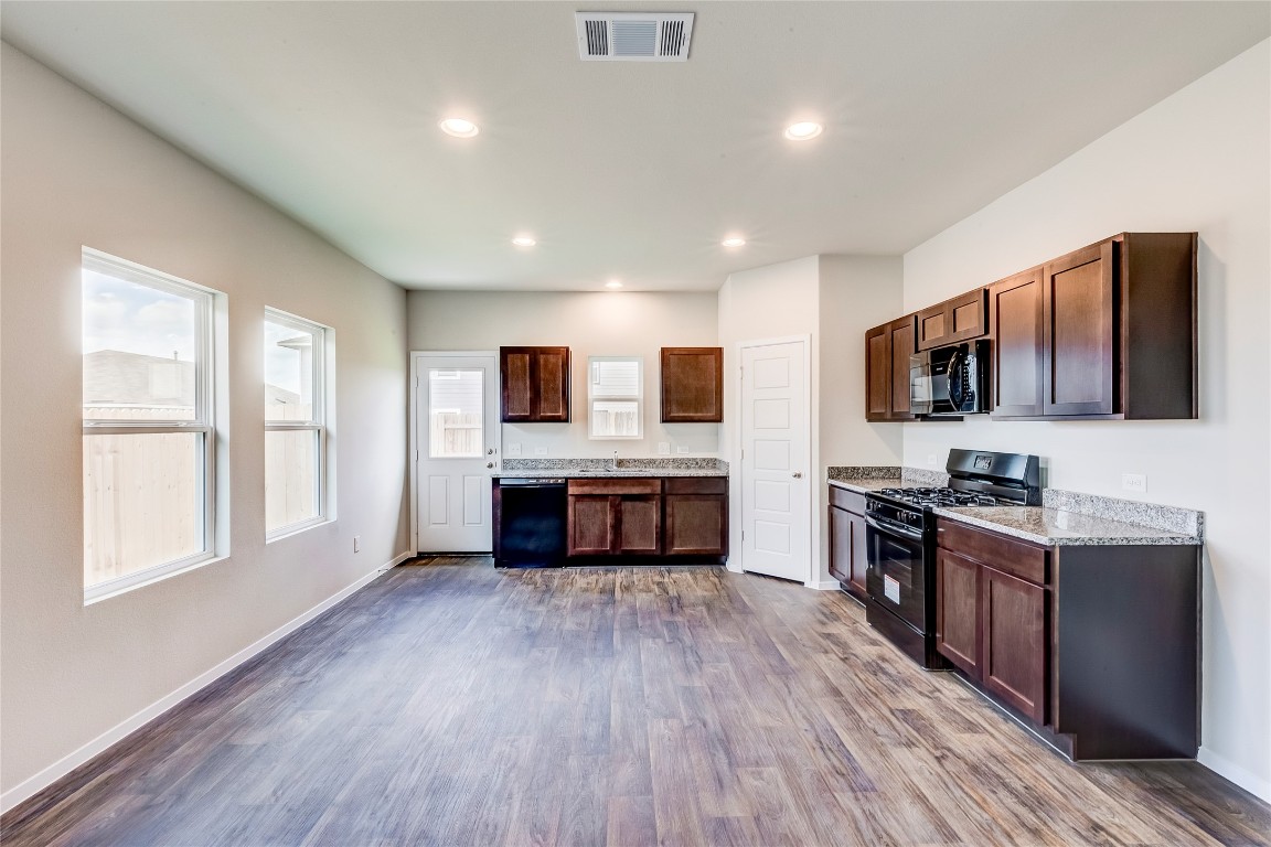 274 Jade Street Maxwell, TX 78656 - Photo 2 of 36 a large kitchen with stainless steel appliances wooden floors and wooden cabinets