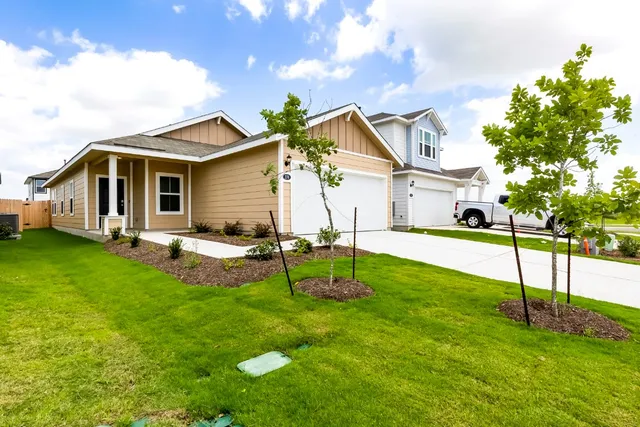 a front view of house with yard and garage