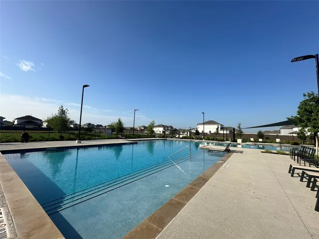 a view of swimming pool with table and chairs under an umbrella