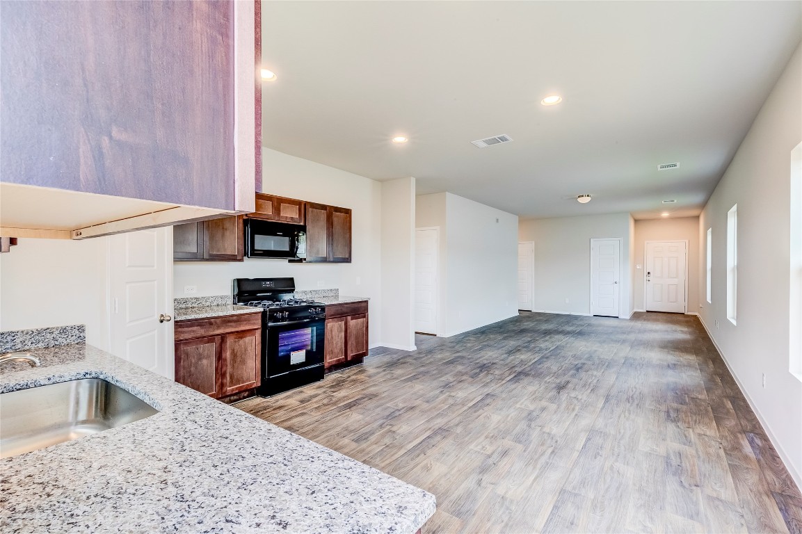 274 Jade Street Maxwell, TX 78656 - Photo 35 of 36 a kitchen with stainless steel appliances granite countertop a stove a sink and a refrigerator