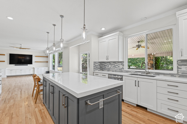 10664 Trail Ridge Circle Sandy, UT 84092 - Photo 65 of 113 Spacious kitchen with a central island featuring a light-toned countertop, white cabinetry with modern hardware, and a tile backsplash