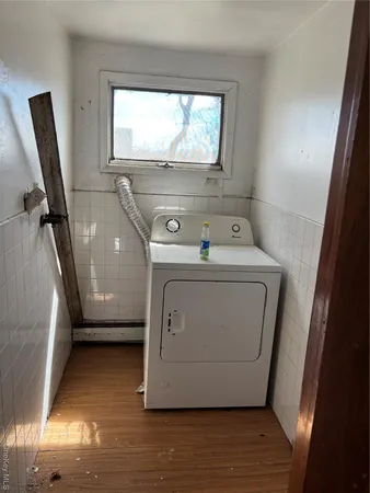 a utility room with wooden floor washer and dryer