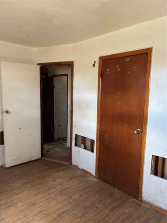 a view of a big room with wooden floor and wardrobe