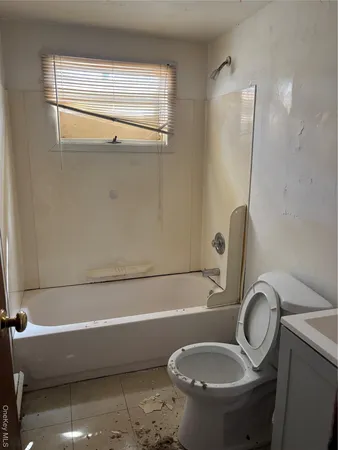 a bathroom with a granite countertop toilet and a sink