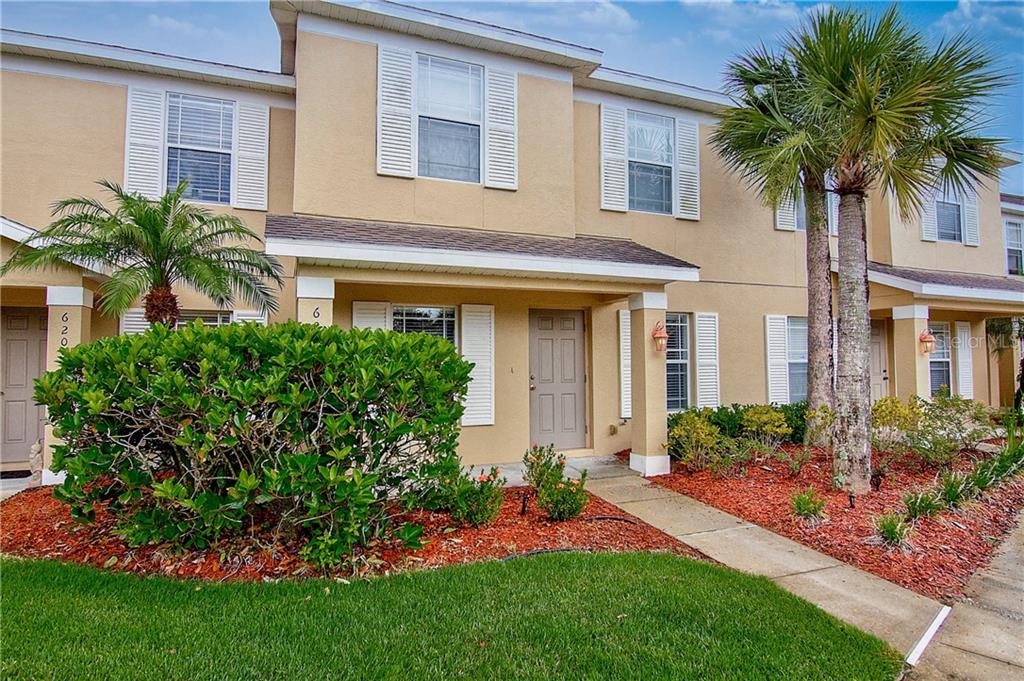6213 Triple Tail Court Lakewood Ranch, FL 34202 - Photo 1 of 1 a front view of a house with a garden and palm trees