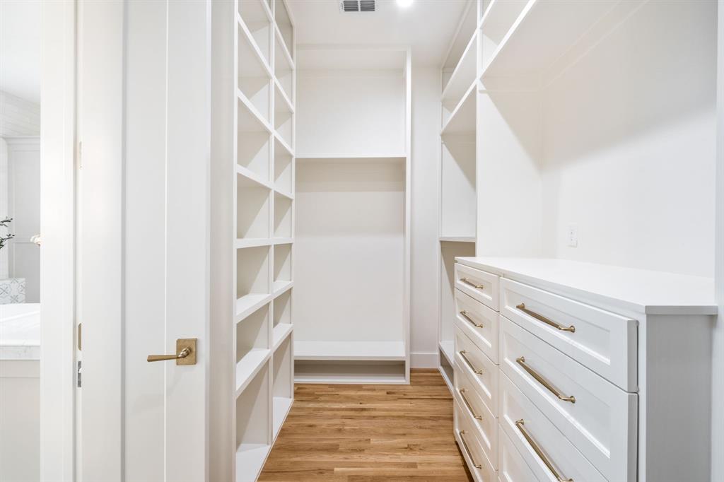 3304 Ferguson Road Grapevine, TX 76092 - Photo 28 of 38 Custom closet system featuring extensive shelving, built-in drawer storage with brushed gold hardware, wood-finish flooring, recessed lighting, and a white color palette