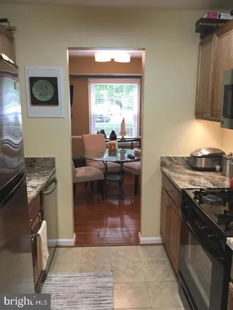 a living room with stainless steel appliances granite countertop a stove a sink and a microwave