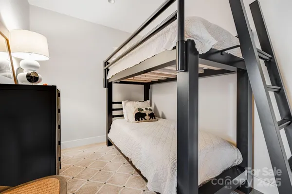 a bedroom with a bed and large windows