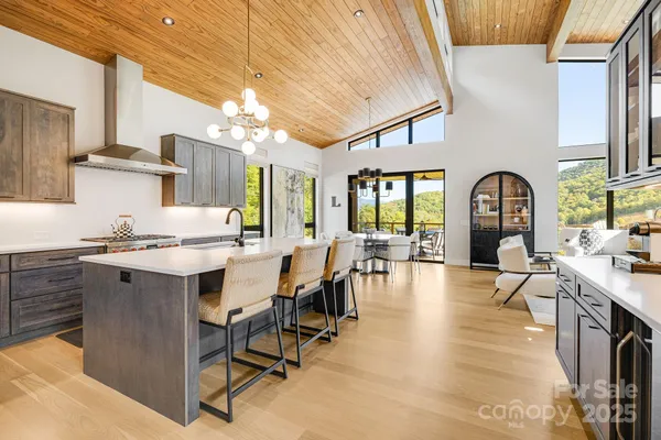 a large kitchen with stainless steel appliances a dining table chairs and a large window