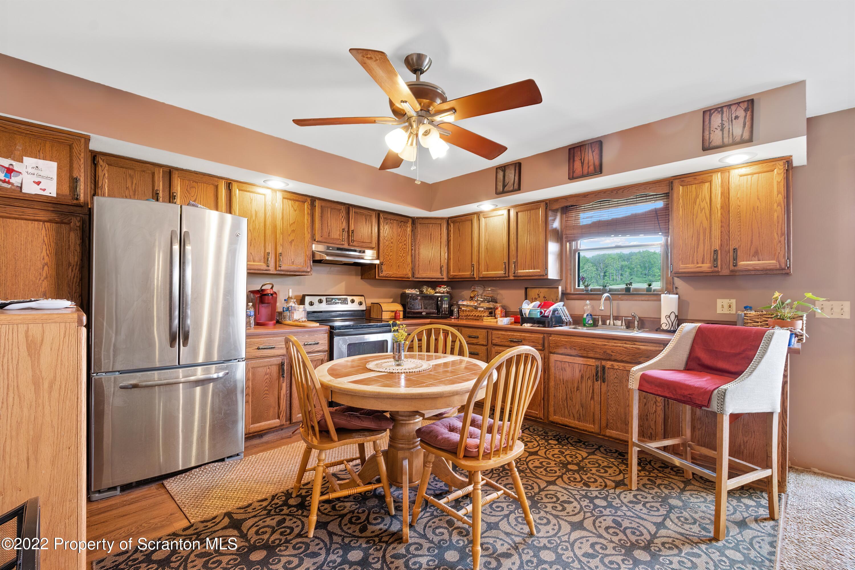 116 Hack Road Dalton, PA 18414 - Photo 15 of 33 a kitchen with a refrigerator a dining table and chairs
