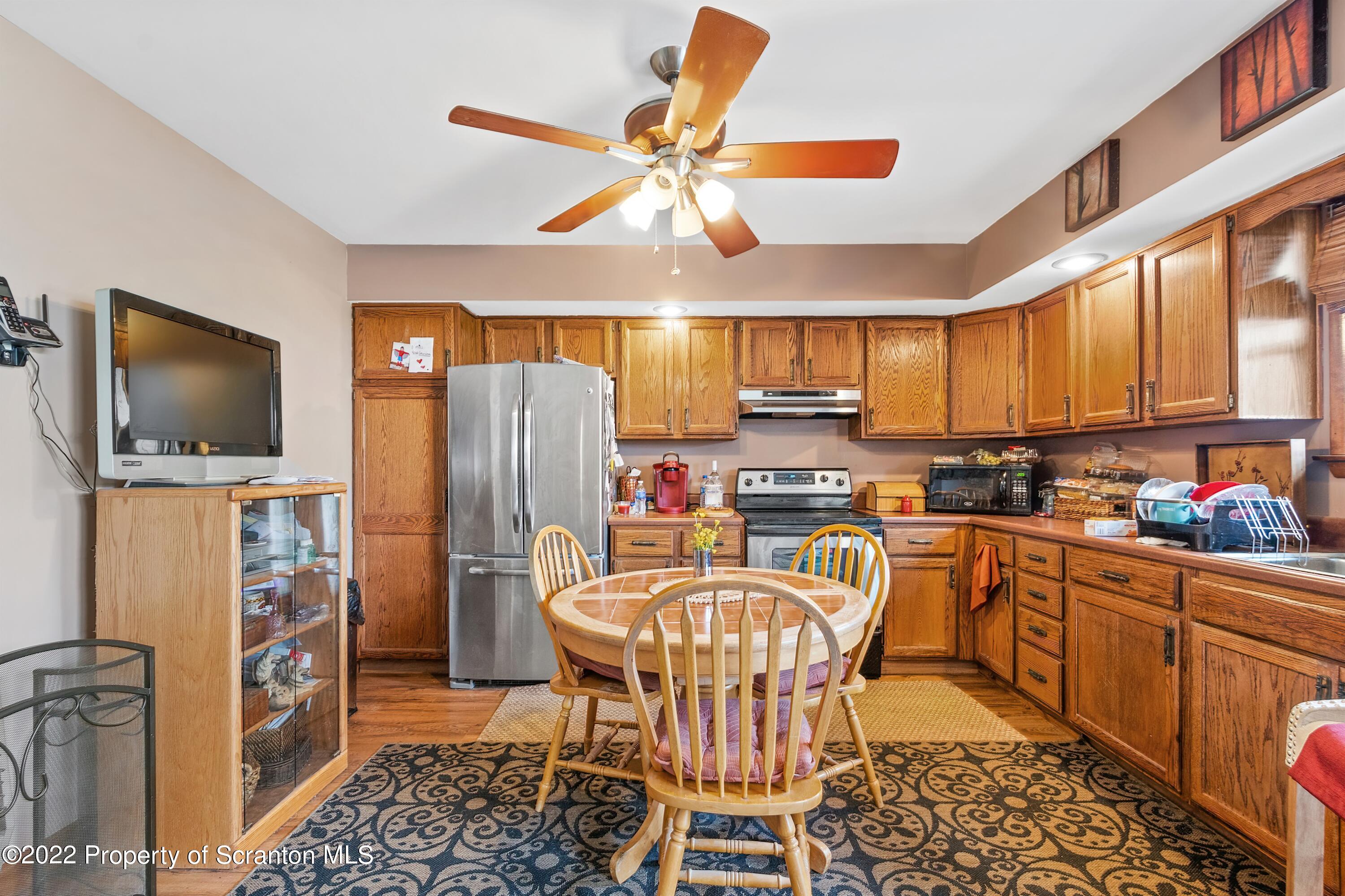 116 Hack Road Dalton, PA 18414 - Photo 16 of 33 a kitchen with stainless steel appliances a dining table chairs refrigerator and microwave