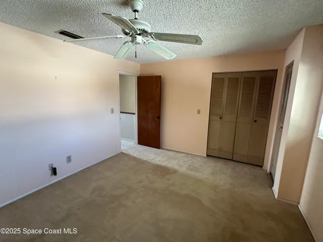 an empty room with a ceiling fan and a window