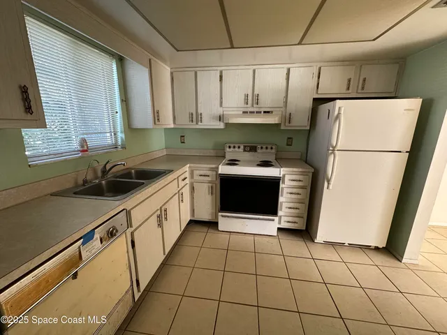 a kitchen with stainless steel appliances a refrigerator sink and cabinets