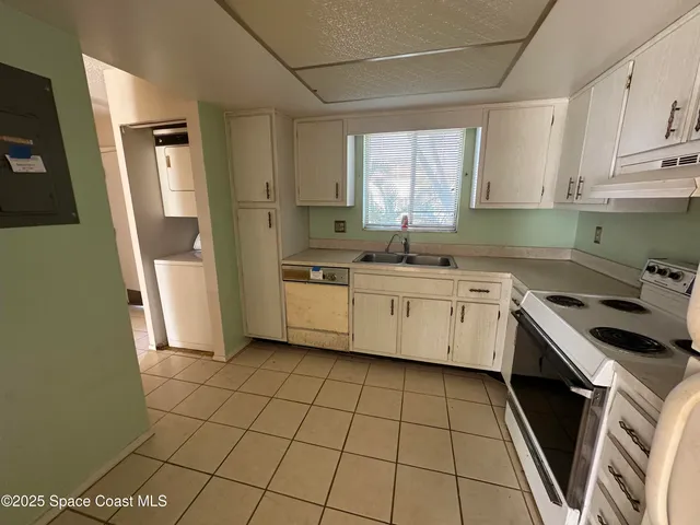 a kitchen with a sink a stove a refrigerator and cabinets