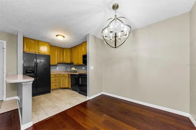 a view of a kitchen with wooden floor and a ceiling fan