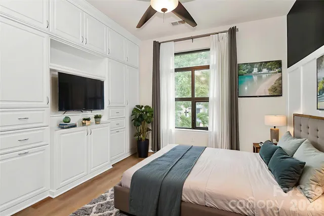 a bedroom with a bed tv and window