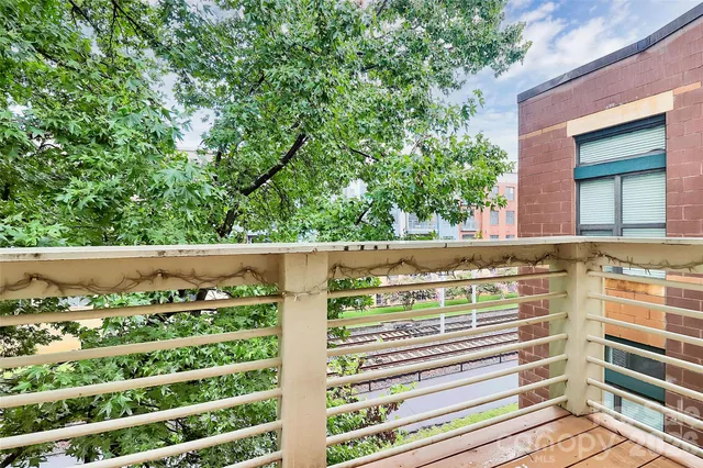a view of balcony with wooden floor and fence
