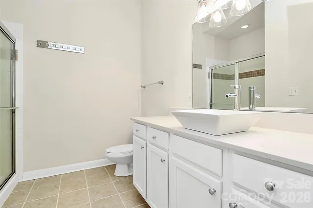 a bathroom with a granite countertop sink a toilet and a mirror