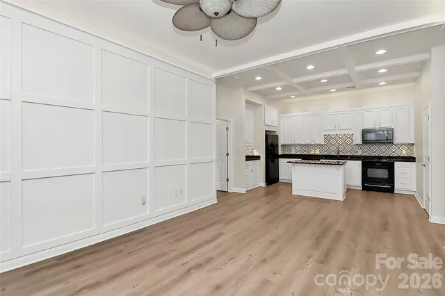 a view of kitchen with granite countertop cabinets and refrigerator