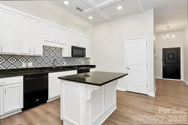 a kitchen with stainless steel appliances granite countertop a sink and a refrigerator