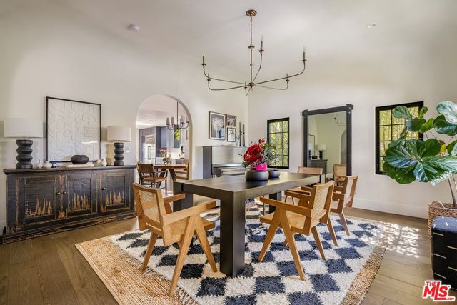 a living room with furniture a chandelier and a dining table