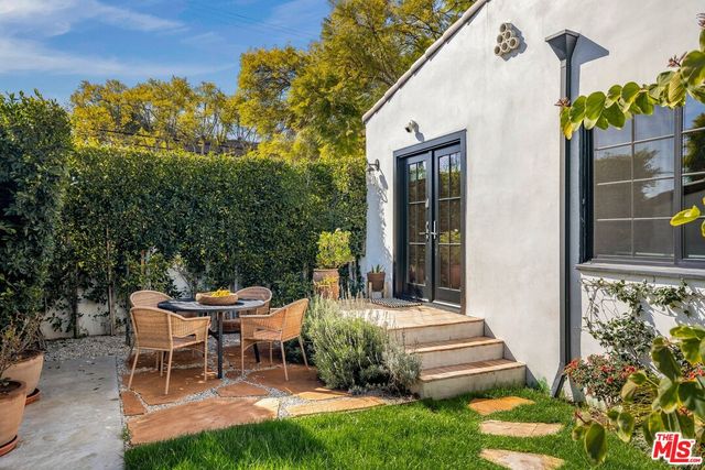 a backyard of a house with table and chairs