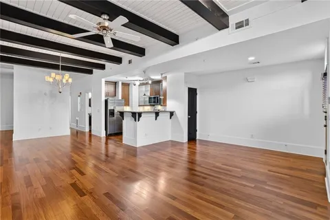 a view of a electric appliances in kitchen and empty room with wooden floor