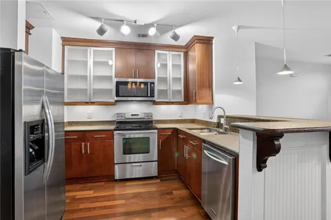 a kitchen with stainless steel appliances granite countertop a stove a sink and a microwave