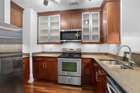 a kitchen with granite countertop a stove top oven sink and cabinets
