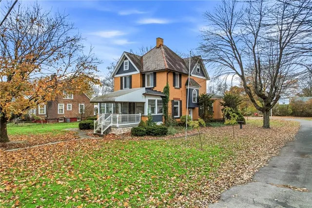 a front view of a house with a yard garden and outdoor seating