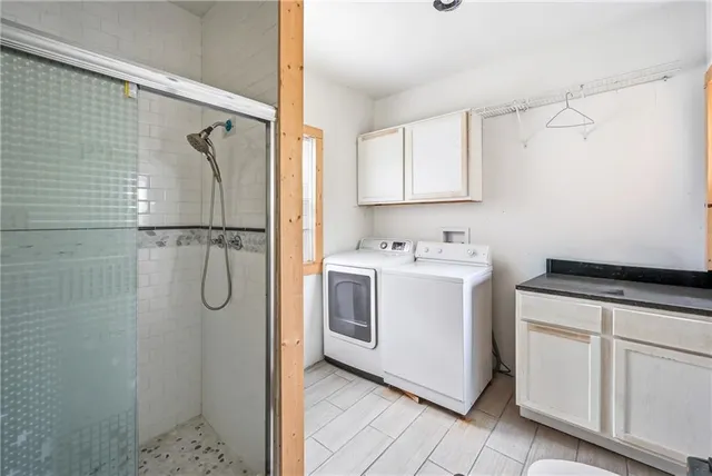 a utility room with cabinets washer and dryer