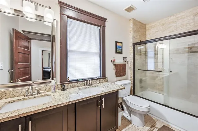 a bathroom with a granite countertop sink toilet and shower