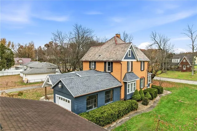 an aerial view of a house with a yard table and chairs